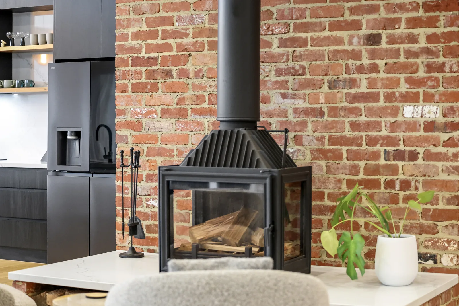 Living area with brick wall and freestanding fireplace