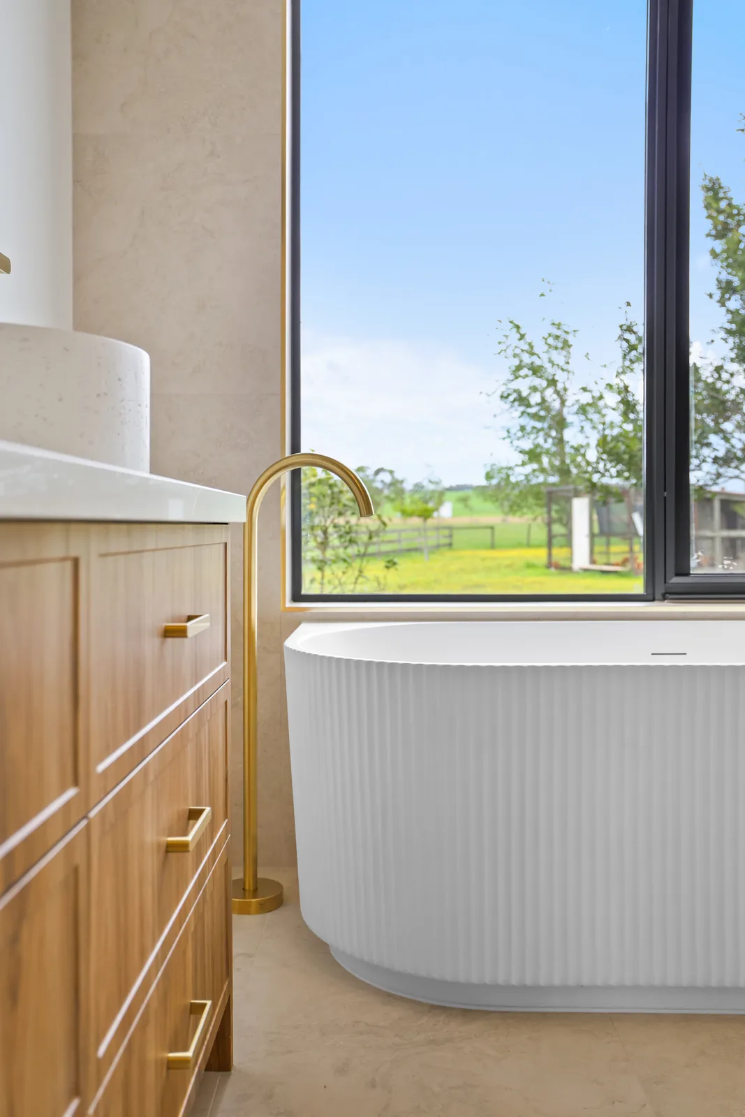 Fluted freestanding bath with brass tapware